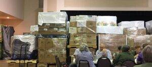 People sitting in front of pallets of emergency supplies