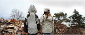 children standing in front of rubble